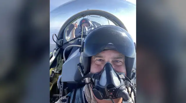 Paco in the F-5 cockpit in flight, back-seater pointing over his shoulder
