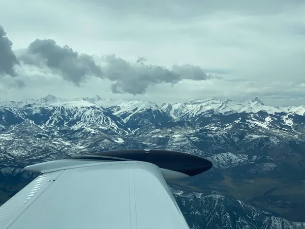 Wing view over snow-capped mountains