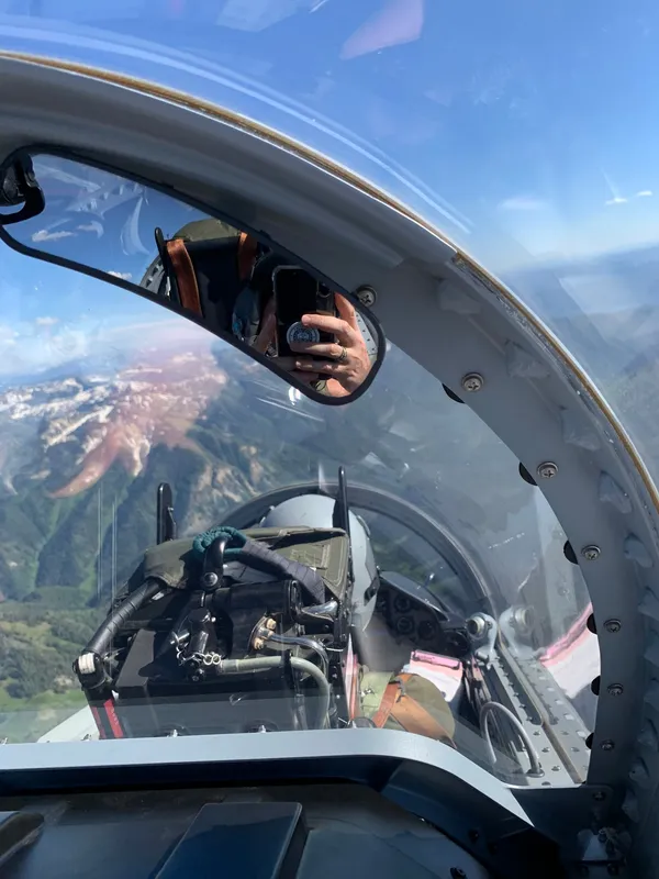 Cockpit canopy view over snow-capped alpine peaks